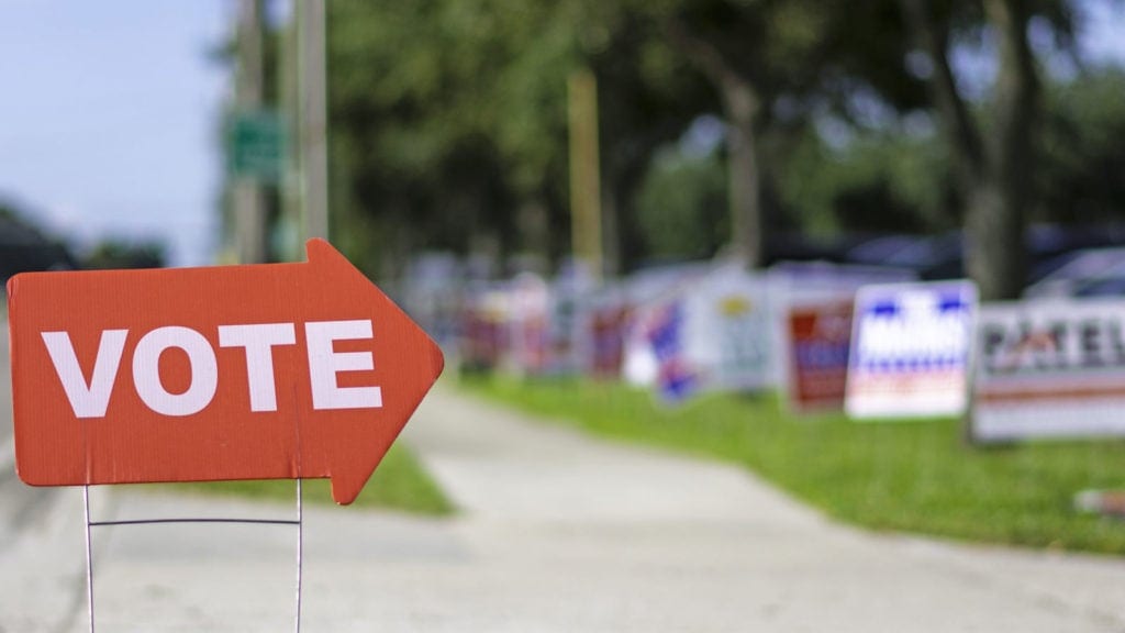 sidewalk lined with political signs