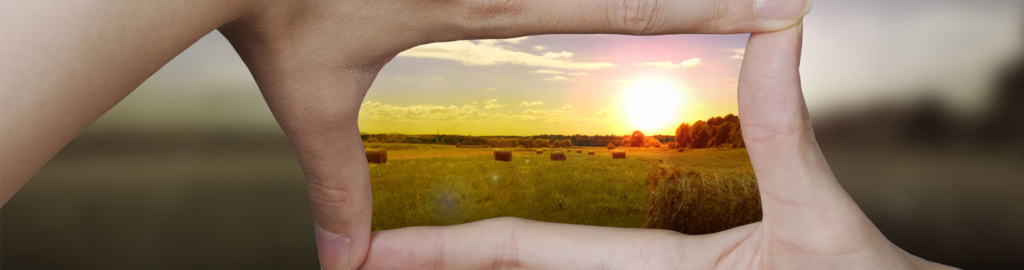 hands held in focus of a landscape